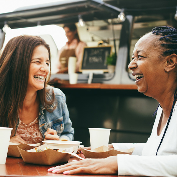 women laughing outside of food truck