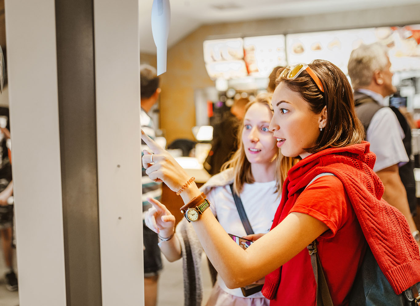 women ordering on screen at quick-service restaurant